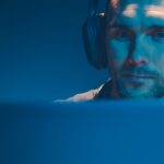 Previdência Privada: uma opção de proteção e planejamento financeiro cada vez mais necessária em nossa sociedade men listening podcast on his wireless headphones